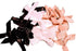 Assorted black, white, and pink hair bows on a green cutting mat.
