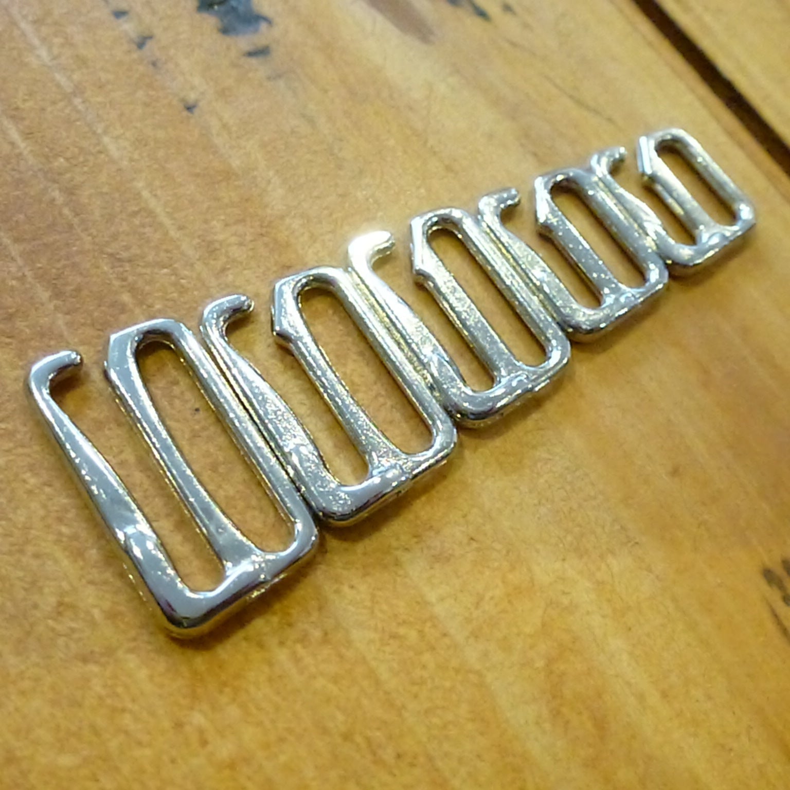 Nickel plated bra or swim hooks on a wood surface