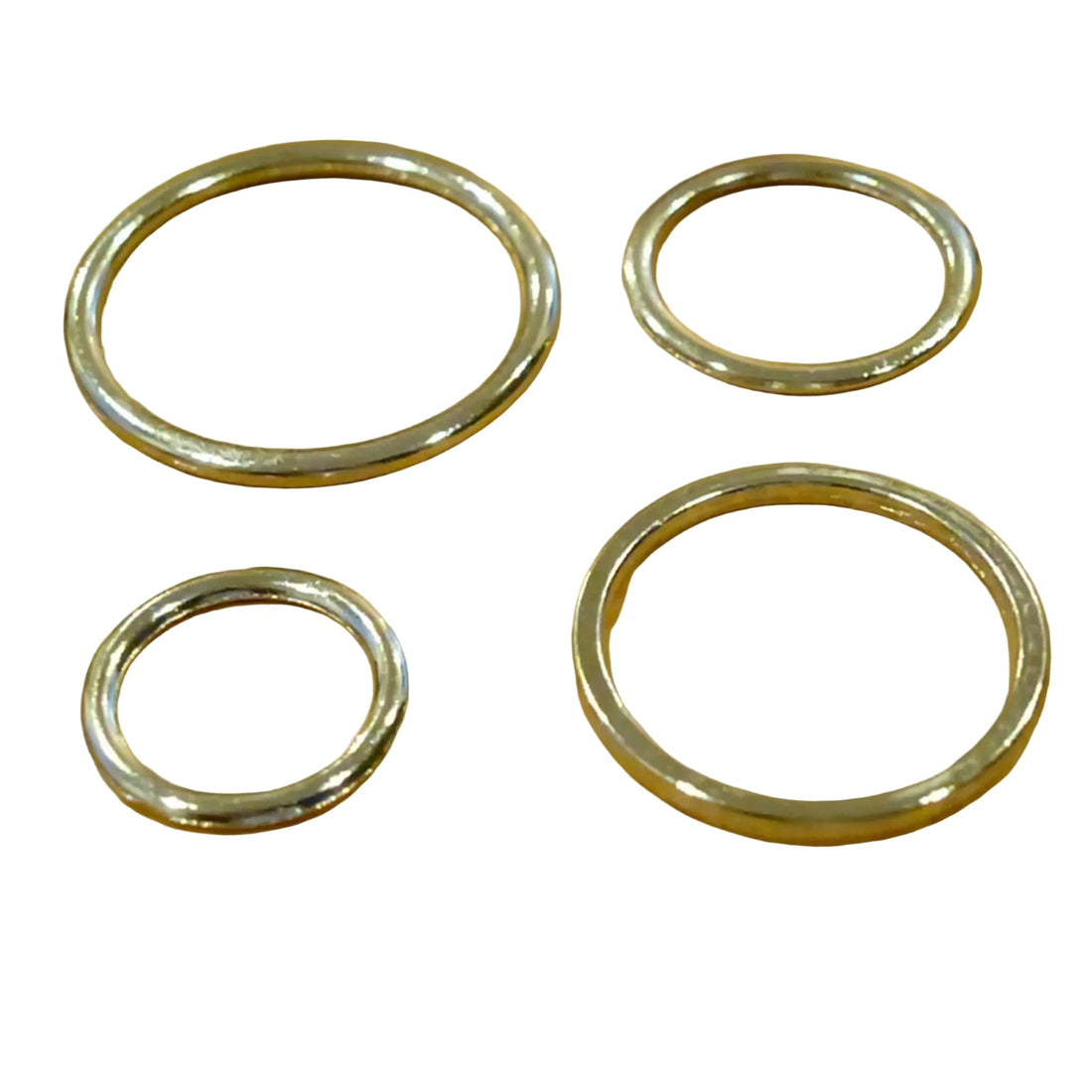 Four metallic rings of different sizes on a wooden surface